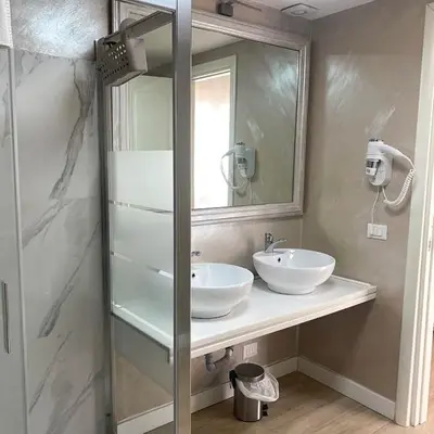 a bathroom with two sinks and a mirror at Relais Villa Coppedè in Rome