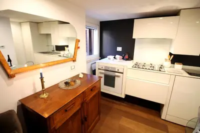 a kitchen with white appliances and a wooden table at Charm & Design in Gourmet District in Rome