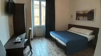 a bedroom with a bed and a table and a window at Roma My Home B&B in Rome