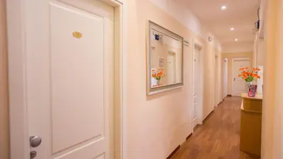 a hallway with a white door and flowers on the wall at Hotel Martino Ai Monti in Rome
