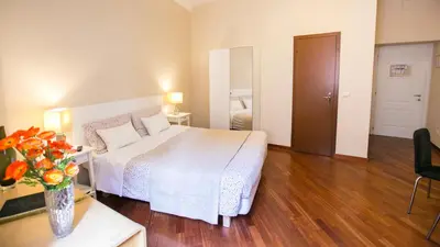 a hotel room with a bed and a vase of flowers at Hotel Martino Ai Monti in Rome