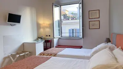 a hotel room with two beds and a window at NTB Roma B&B in Rome