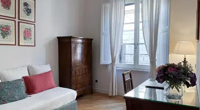 a living room with a couch and a table and a window at NTB Roma B&B in Rome