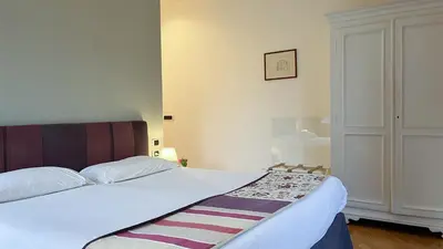 a bedroom with a large bed with white sheets at NTB Roma B&B in Rome