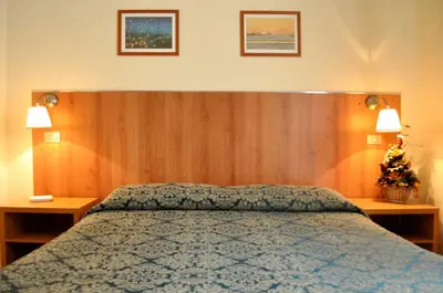 a bedroom with a bed with two tables and two lamps at Hotel Fiorenza in Rome