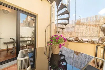 a balcony with a flower pot on a building at CS Campo de'Fiori - Navona Amazing Terrace Apartment in Rome