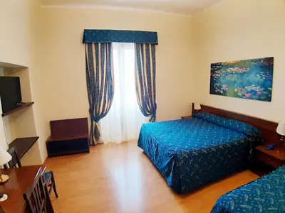 a bedroom with a blue bed and a window at Colosseo Roma in Rome
