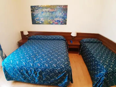 a bedroom with two beds and a painting on the wall at Colosseo Roma in Rome