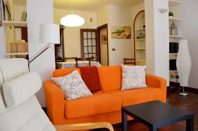 an orange couch in a living room with a table at Holiday in Rome in Rome