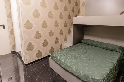 a small bedroom with a bed with a green cover at Hostel Beautiful in Rome