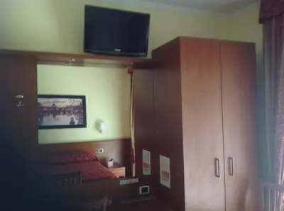 a bedroom with a bed and a cabinet and a television at Residenza Fermi in Rome