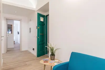 a living room with a green door and a blue couch at Roma Station House in Rome