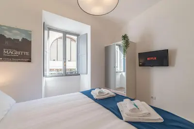 a bedroom with a bed and a tv and windows at Roma Station House in Rome