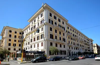 a large white building with cars parked in front of it at La Design.aTA Experience Bed & Breakfast in Rome
