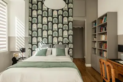 a bedroom with a large bed with a wall of plates at La Design.aTA Experience Bed & Breakfast in Rome
