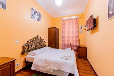 a bedroom with a bed and a television in it at Flower guesthouse in Rome