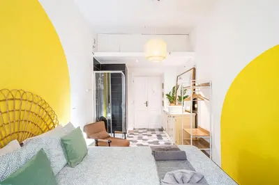 a living room with a bed and a yellow wall at BigFamilyRome - Testaccio Riverside in Rome