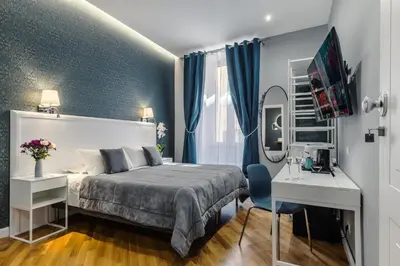 a bedroom with a bed and a desk and a mirror at Bed And Best in Rome