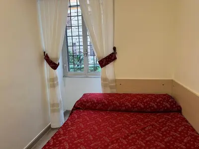 a bedroom with a red bed and a window at Casa Vacanza Vahid in Rome
