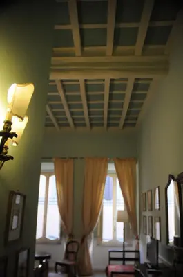 a room with a ceiling and windows with curtains at Relais Teatro Argentina in Rome