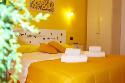 a yellow bedroom with a bed with towels on it at Julius Caesar 183 in Rome