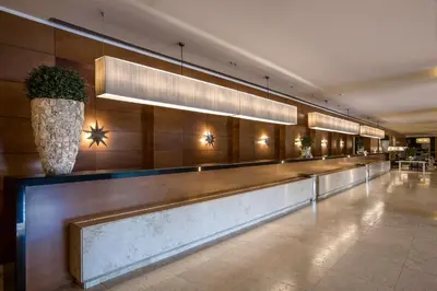 a lobby with a long counter with a vase at Ergife Palace Hotel in Rome