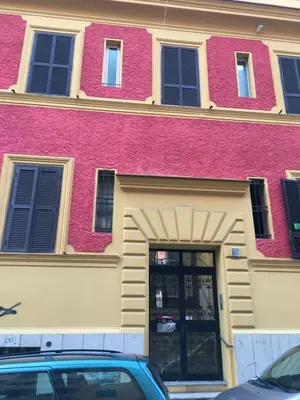 a pink and yellow building with a door at Casa Camilla in Rome
