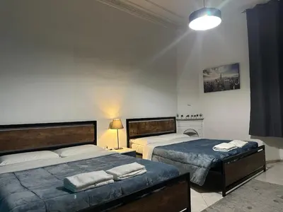 a bedroom with two beds and a lamp at Kobe's Apartment in Rome