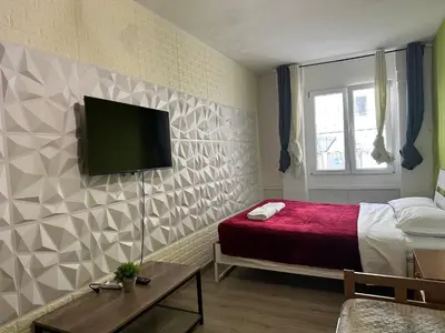 a bedroom with a bed and a tv on a wall at Kobe's Apartment in Rome