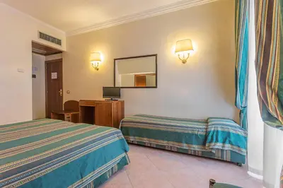 a hotel room with two beds and a mirror at Raeli Hotel Floridia in Rome