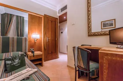 a room with a bed and a desk and a tv at Raeli Hotel Floridia in Rome