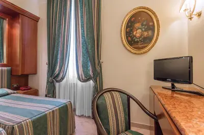 a room with a bed and a tv and a window at Raeli Hotel Floridia in Rome
