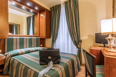a hotel room with a bed and a mirror at Raeli Hotel Archimede in Rome
