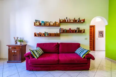 a red couch in a living room with green walls at Apartment Angelo Emo 69 in Rome