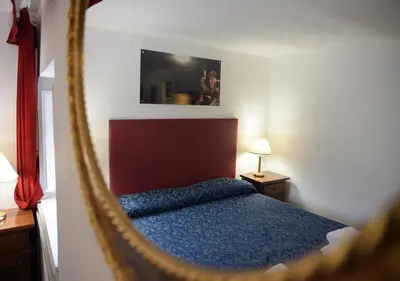 a bedroom with a mirror and a blue bed at Farnese 48 in Rome