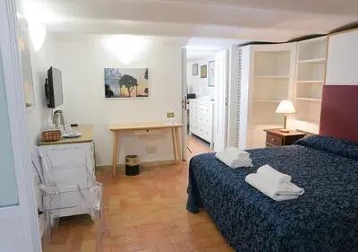 a bedroom with a bed and a desk with a chair at Farnese 48 in Rome