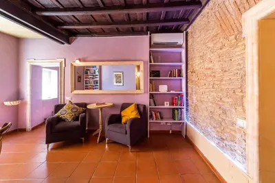 a room with two chairs and a table and a brick wall at maison specchi in Rome