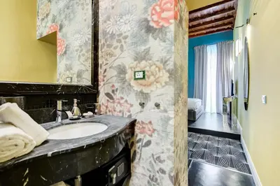 a bathroom with a sink and a mirror at The French suites by oneup Hospitality in Rome