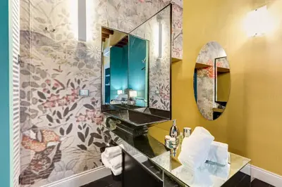a bathroom with a sink and a mirror at The French suites by oneup Hospitality in Rome