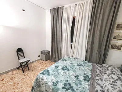 a bedroom with a bed and a chair and a window at In the Heart of Rome in Rome