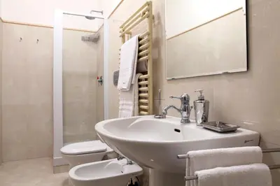 a bathroom with a sink and a toilet and a mirror at Dimora storica Palazzo Marescalchi Belli in Rome