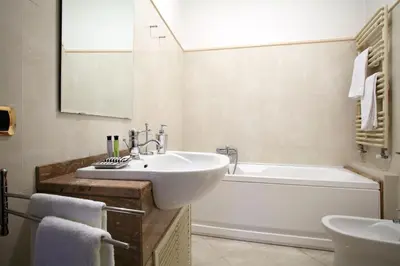 a white bathroom with a sink and a tub and a sink at Dimora storica Palazzo Marescalchi Belli in Rome