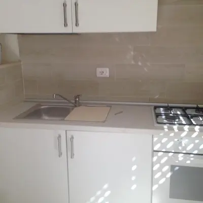 a kitchen with white cabinets and a sink at flaminio heart house in Rome