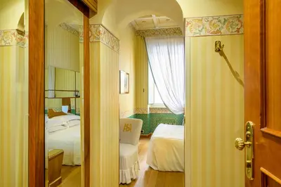 a hallway to a bedroom with two beds and a window at Hotel S. Anna in Rome