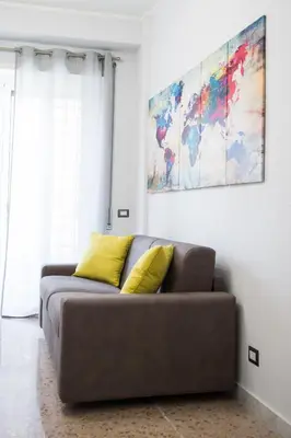 a couch with two yellow pillows in a living room at Enjoy Porta Furba in Rome