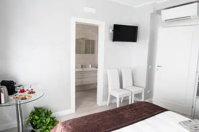 a white room with a bed and a table and chairs at Il Magnificus Boutique in Rome