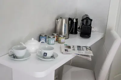 a white shelf with cups and tea cups on it at Il Magnificus Boutique in Rome