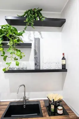 a kitchen with a sink and a shelf with wine glasses at Il Magnificus Boutique in Rome