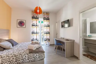 a bedroom with a bed and a desk and a sink at La Casa di Anto - San Giovanni in Rome