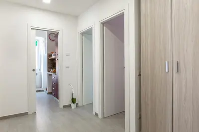 a hallway with white walls and wooden doors at La Casa di Anto - San Giovanni in Rome